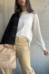 Remera blanca de mangas largas con detalle de encaje en las mangas.