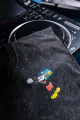 Musculosa negra con efecto nevado y estampado de Mickey Mouse escuchando música con un radiocasete. Corte oversize.