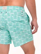 Short de baño celeste con estampado de ballenas en azul y gris. Tiene cintura elástica con cordón ajustable y bolsillos laterales.