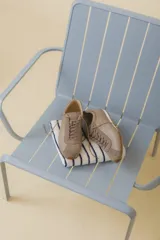 Zapatilla tipo runner color gris claro, de cuero y gamuza combinada, con suela de caucho blanca.