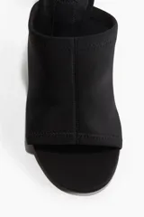 Sandalias negras con punta redonda y tira ancha en tejido elástico en el empeine. Taco de carrete.