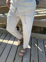 Pantalón de lino color beige, de corte recto y con cordón ajustable en la cintura.