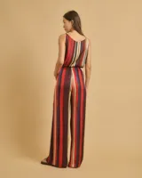 Pantalón de pinzas de talle alto con cintura elástica, bolsillos delanteros y pierna recta. Diseño a rayas verticales en tonos rojo, azul, beige y marrón.