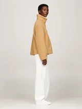 Campera color beige de tejido polar de peluche, con cuello alto, cierre de cremallera, bolsillos laterales y puños elásticos.