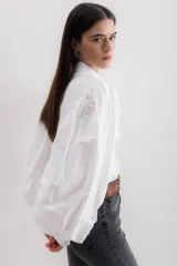 Camisa color beige de algodón con mangas abullonadas y cierre con botones.