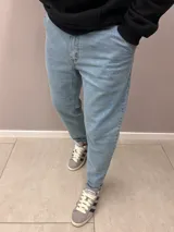 Pantalón de jean celeste de corte slouchy, con tiro alto y bolsillos laterales.