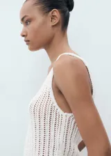 Top blanco de punto calado, sin mangas y con cuello redondo.