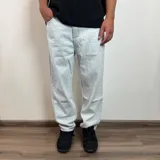 Jean de hombre color negro con efecto lavado, de corte mom fit, con cintura elástica y puños ajustados en los tobillos.