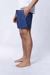 Short de baño azul con estampado de hojas en tonos más oscuros.