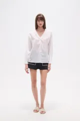 Blusa de algodón color menta, con escote en V, mangas largas y detalles de bordado floral y mostacillas en los hombros y el escote.