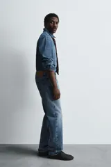 Camisa relaxed fit confeccionada en denim de algodón con cuello solapa, manga larga con puño abotonado, efecto lavado medio y cierre frontal con botones.