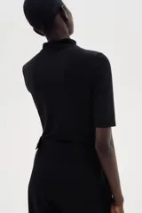 Top entallado negro de microfibra suave con cuello alto y manga francesa.