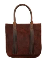 Bolso tipo shopper de piel con pelo en tonos marrones, bordes cosidos a mano con hilo grueso y dos asas de cuero trenzado con flecos largos colgantes.