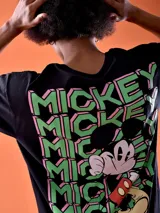 Remera negra de corte oversized con estampado pequeño en el pecho con la palabra "Mickey" en color verde.