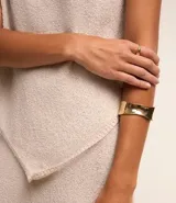 Blusa de punto color beige, sin mangas, con escote redondo y bajo asimétrico.