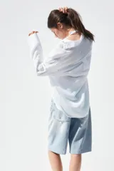 Camisa color durazno confeccionada en algodón, de corte amplio, con cuello solapa, manga larga con puños abotonados, hombros caídos, bolsillo de parche en el pecho, pinzas en la espalda y cierre frontal con botones.