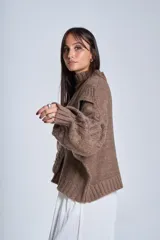 Sweater blanco de punto con cuello alto, diseño de ochos y volados en los hombros.