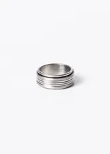 Anillo plateado de acero quirúrgico con tres ranuras que permiten que la parte central gire.
