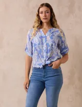 Blusa de gasa estampada azul con diseño paisley, marca Ruby Rd. Cuello a la base, escote en v y abertura con botones. Delantera con bolsillos. Largo de manga regulable con presilla y botón. Terminación de ruedo con nudo.