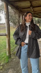 Sobrecamisa gris de paño con cuello camisero, cierre frontal con botones, dos bolsillos de parche en el pecho y corte holgado.