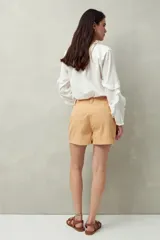Short blanco de tiro alto con bolsillos delanteros con solapa y botones a la vista.