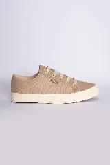 Zapatillas bajas color beige claro, con cordones y suela blanca.