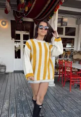 Sweater de lana color crema con rayas verticales anchas color amarillo mostaza, de corte holgado y cuello redondo. Tejido a mano.