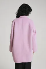 Tapado gris con doble botonadura, solapas amplias y corte holgado.