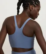 Top deportivo celeste con escote nadador en la espalda y fruncido delantero.