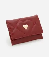 Billetera pequeña tipo sobre color bordó, confeccionada en poliuretano con textura capitoneada y aplique de corazón dorado.