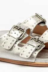 Sandalias marrones de cuero vacuno con doble tira y hebillas metálicas ajustables.