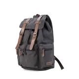 Mochila de tela canvas color verde oliva con tapa y detalles en símil cuero marrón. Cierre superior marinero, bolsillos internos, externos frontal, laterales y trasero con cierre. Asas rígidas, correas ajustables y espacio para laptop de 15".