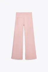 Pantalón de jean color rosa, de tiro alto, corte recto y largo hasta el tobillo. Presenta bolsillos de parche delanteros y traseros, trabillas en la cintura y cierre frontal con cremallera y botón.