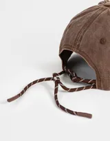 Gorra de gabardina color marrón con efecto lavado y bordado frontal con la frase "Another Cap". Ajuste trasero con hebilla metálica.