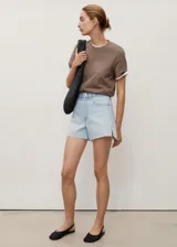 Short de jean de tiro medio, color celeste claro, con bajo deshilachado y aberturas laterales en el ruedo.