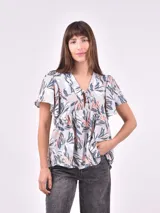 Blusa estampada con cuello en V, mangas cortas con volados y detalle de lazo en el escote.