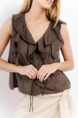 Blusa blanca de algodón con escote en V, volados en el frente y mangas cortas.