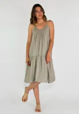 Vestido midi color beige, de corte suelto, con breteles finos y falda escalonada.
