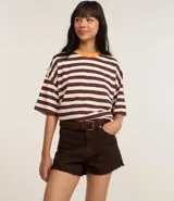 Short de sarga color blanco, modelo slim, con trabillas en la cintura, bolsillos, cierre delantero con botón y cremallera, y terminación deshilachada.