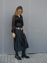 Falda midi negra de raso con corte al bies y silueta en línea A suave.