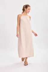 Vestido largo color beige, de corte recto y breteles finos.