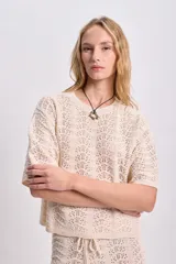 Top de punto calado color crudo con cuello redondo y mangas cortas.