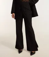 Pantalón de viscosa con corte flare, cintura alta, sin estampa, con frisos delanteros y abertura lateral en el bajo.