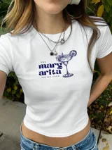 Remera blanca de algodón con estampado de cerezas rojas con moño. Corte clásico y mangas cortas.