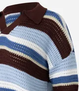 Remera oversized de punto con rayas horizontales en tonos marrón, celeste y blanco. Presenta cuello polo y mangas cortas.