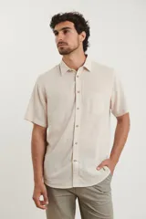 Camisa sport de manga corta, color beige, con botones de coco y bolsillo en el pecho.