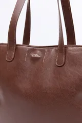Cartera tipo tote bag en símil cuero color marrón oscuro, con bordados decorativos en blanco que evocan un estilo western. Cuenta con asas largas para llevar al hombro.