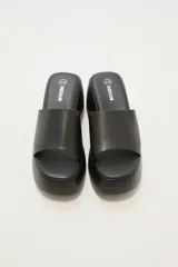 Sandalias negras con plataforma y tira ancha sobre el empeine.