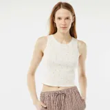 Camiseta de tirantes corta color blanco, de punto pointelle con estampado de limones y detalle de encaje en el cuello y sisas.