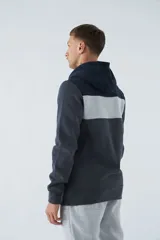 Buzo canguro de felpa gris oscuro con capucha ajustable, bolsillo canguro y logo estampado en el pecho. Tiene una banda horizontal gris claro en la parte superior del pecho y los hombros.